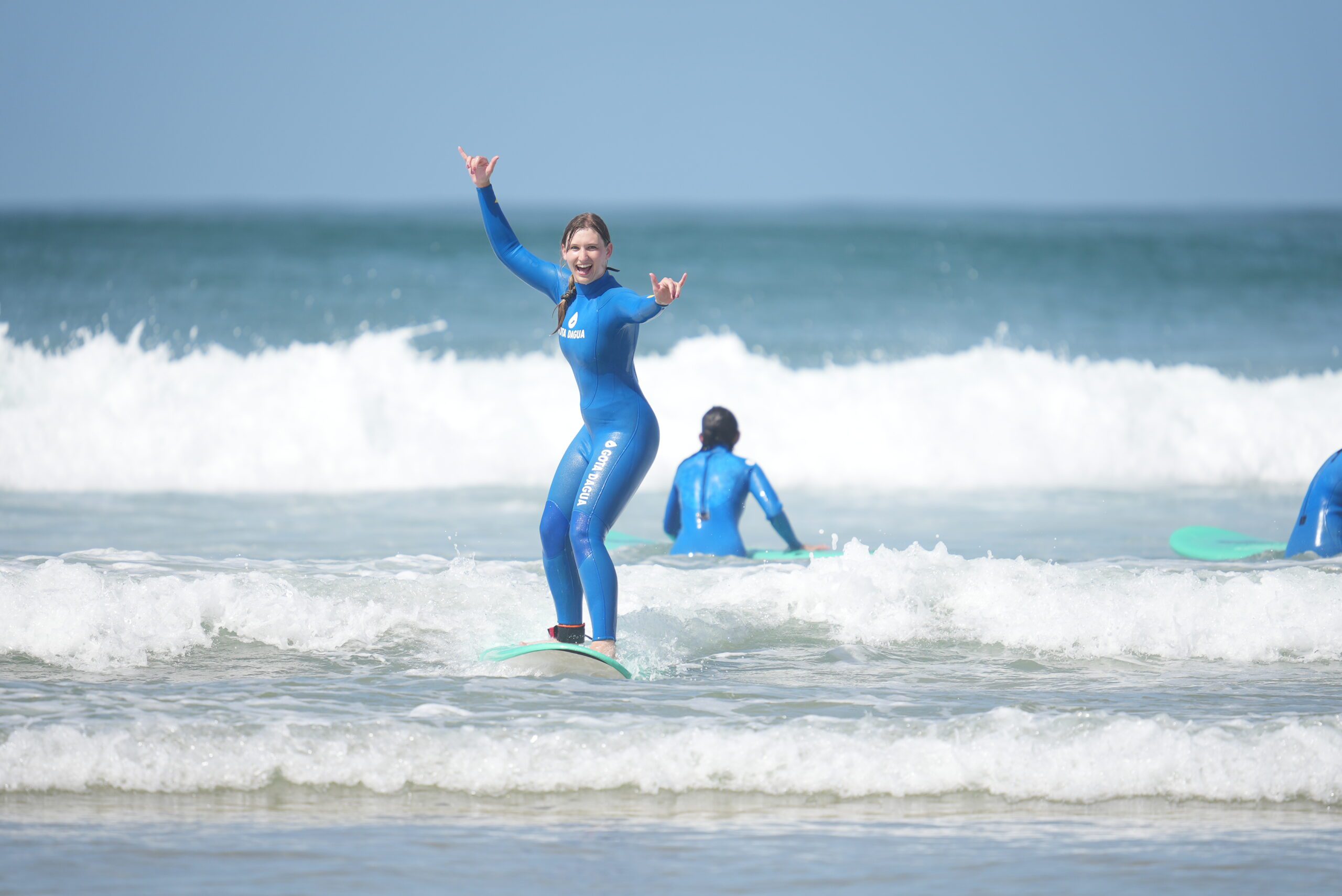 A girl catching a wave in a surf lesson