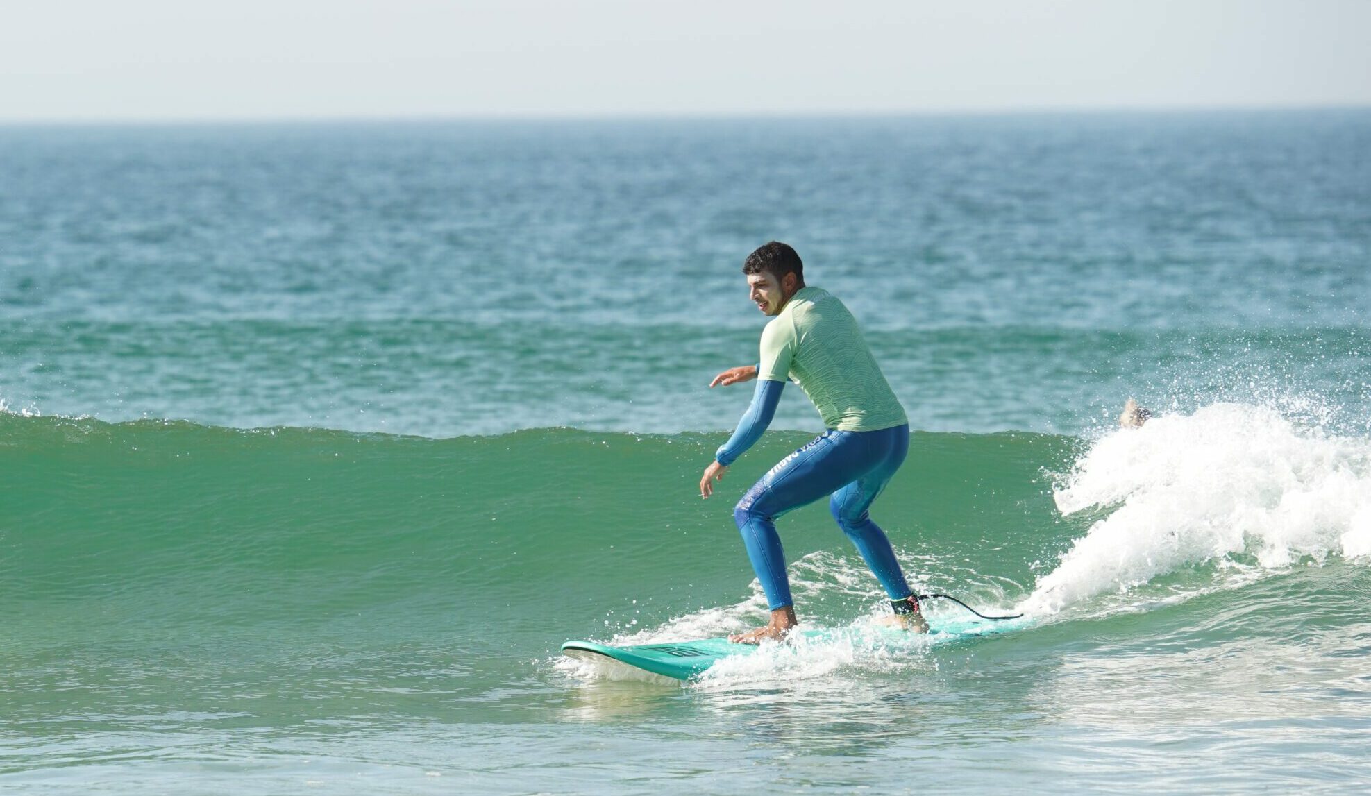 A guy on a surf board catching a wave