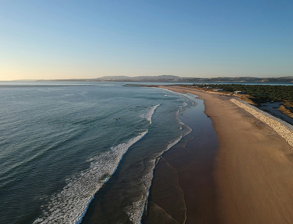 Aerial view of Costa da Caparica beach in Portugal with waves rolling onto the shore