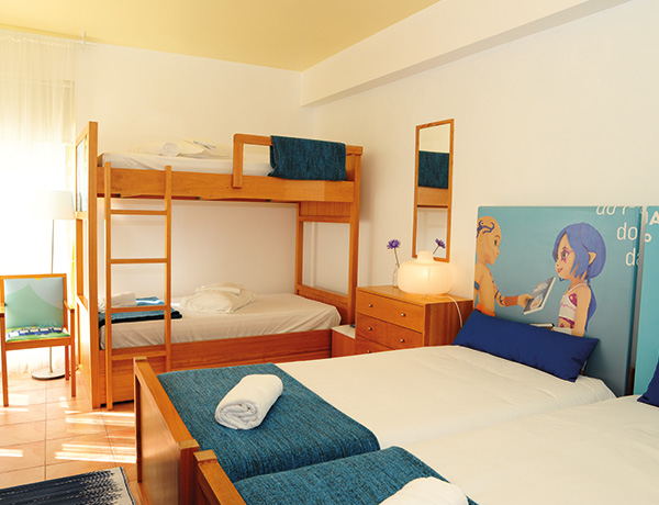 Room with bunk beds and blue towels at our junior surf camp