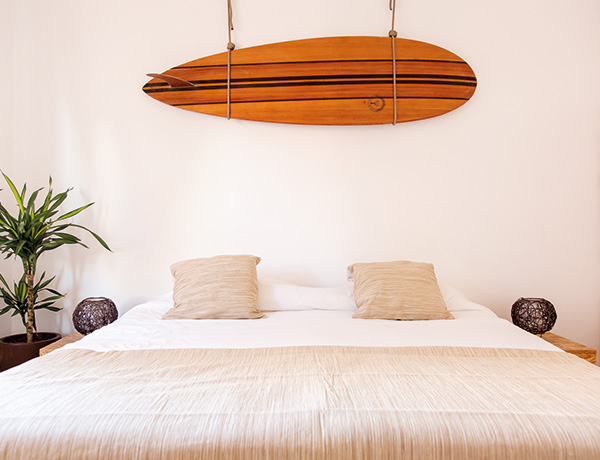 Double bedroom with a wooden surfboard mounted above the bed at our Costa da Caparica surf house