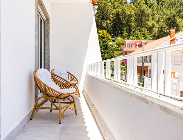 Balcony with a rattan chair overlooking the hillside in Costa da Caparica