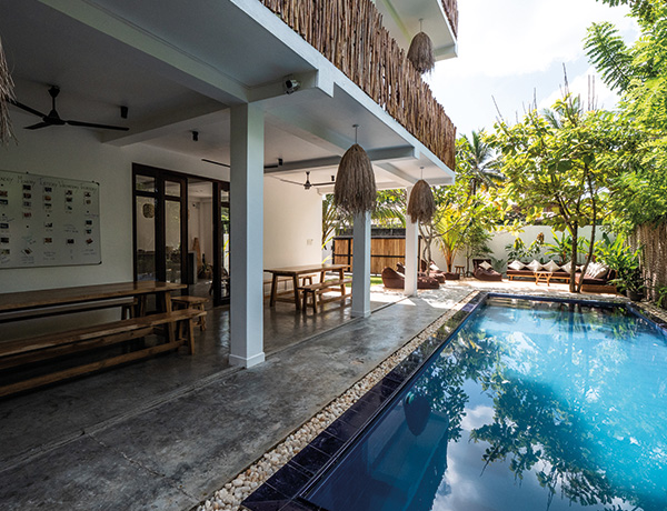 Covered terrace with long tables beside the pool at our surf camp Sri Lanka in Ahangama