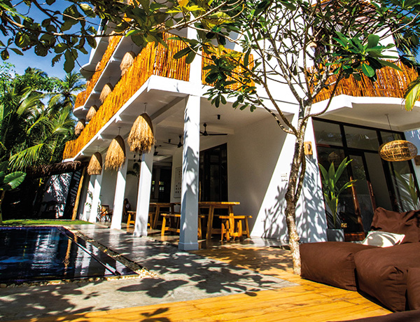 Exterior of our Ahangama surf house with thatched balconies and poolside bean bags
