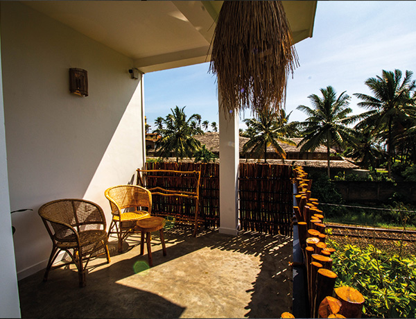 Private balcony with rattan chairs and palm views at our Ahangama surf camp