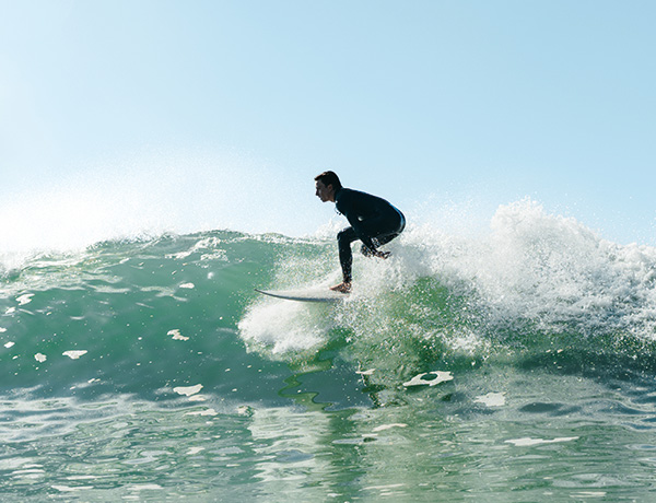 Surfer carving a turn on a breaking wave, spraying whitewater into the air