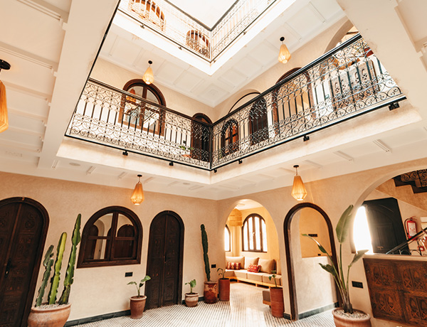 Open courtyard with wrought-iron balconies and arched doorways at our surf camp Morocco riad