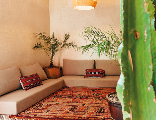 Low seating with a Berber rug and kilim cushions in the lounge of our surf camp Morocco