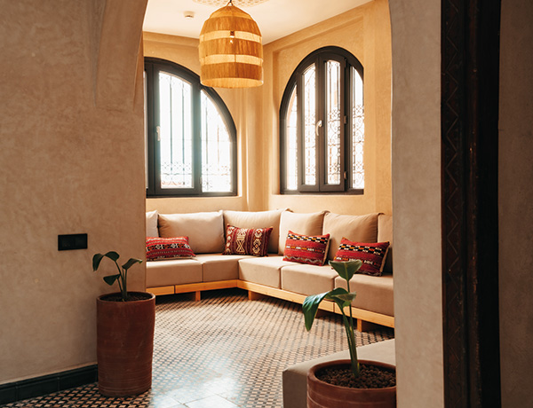 Corner lounge with patterned cushions and a mosaic tiled floor at our Tamraght surf camp