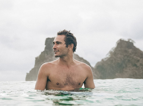 Host treading water by rocky sea stacks during a surf week Sri Lanka in Ahangama