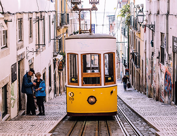 Yellow tram on a cobbled Lisbon street, near our surf coliving Portugal house