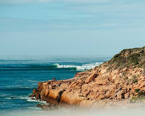 Rocky headland with a peeling wave along Morocco's Atlantic coastline
