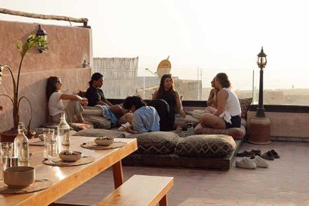 People relaxing on a rooftop terrace at our surf camp Morocco in Tamraght